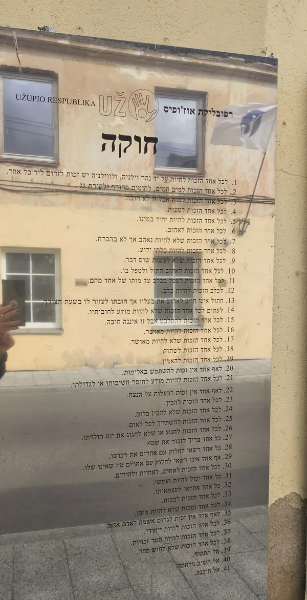 לוח חוקת אוזופיס בעברית על קיר ברובע